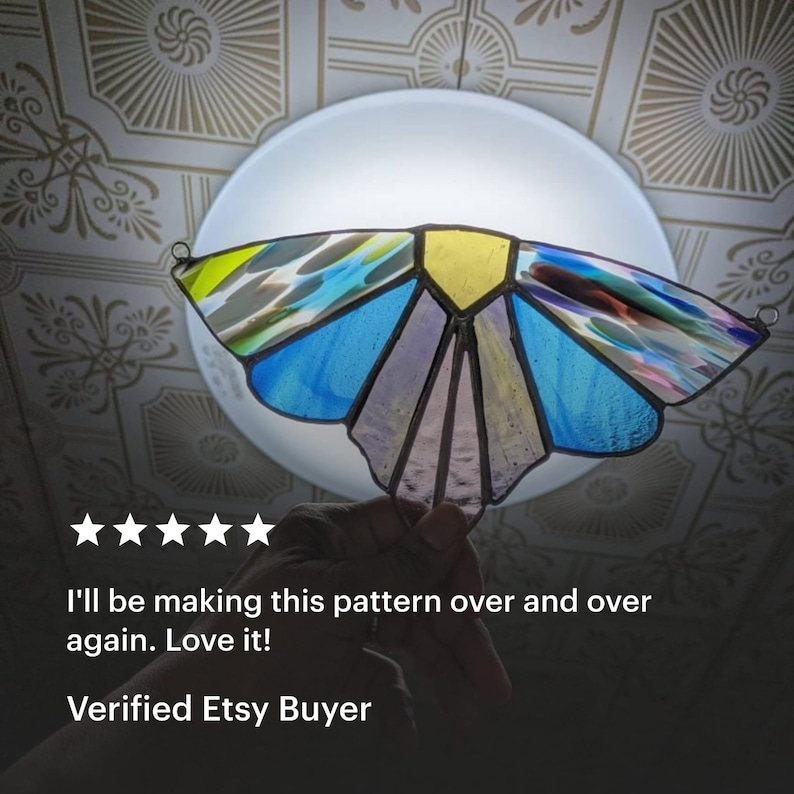 May include: A stained glass butterfly with yellow, blue, and purple wings. The butterfly is held up in front of a light. The text reads: "I'll be making this pattern over and over again. Love it! Verified Etsy Buyer."