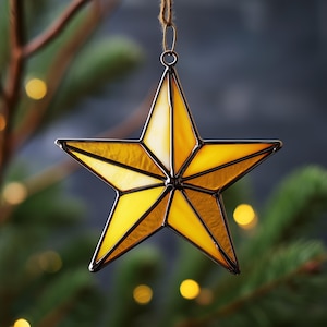 May include: A stained glass star ornament with a five-point design. The star features shades of yellow and gold, with a dark metal border. It hangs from a brown string, perfect for holiday decor. The ornament is approximately 5 inches in diameter.