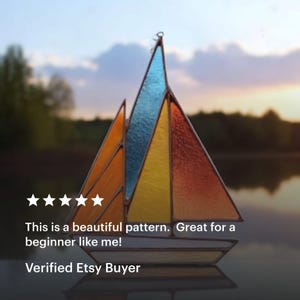 May include: A stained glass sailboat with a colorful design. The sails are composed of orange, yellow, and blue glass panels. The text on the image reads: "This is a beautiful pattern. Great for a beginner like me!" and "Verified Etsy Buyer."
