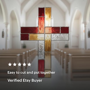 May include: A stained glass cross with a mix of red, gold, and silver panels. The cross is hanging in a church. The text "Easy to cut and put together" and "Verified Etsy Buyer" is displayed below the cross.