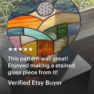May include: A round stained glass piece with a landscape design. The artwork features a colorful scene with orange, blue, yellow, and green glass panels. The text reads: "This pattern was great! Enjoyed making a stained glass piece from it! Verified Etsy Buyer."