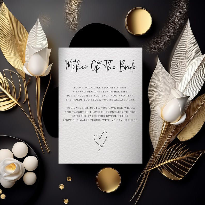 May include: A white rectangular card with black text reading Mother Of The Bride and a poem, centered between two white roses on gold stems and metallic gold leaves. A small hand-drawn heart sits below the text, with gold circular accents nearby.