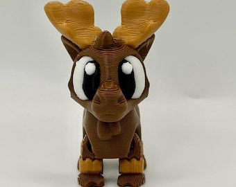 May include: A 3D printed brown reindeer figurine with large, light brown antlers and oversized eyes featuring white sclera and black pupils. The figure has a layered, ridged texture throughout its body, a small snout, and four distinct feet.