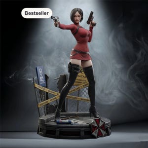 May include: A detailed figurine of a woman in a red dress, holding two pistols. The figure is on a platform with a caution tape barrier and a sign that reads "R.P.D.". The base features a red and white umbrella logo.