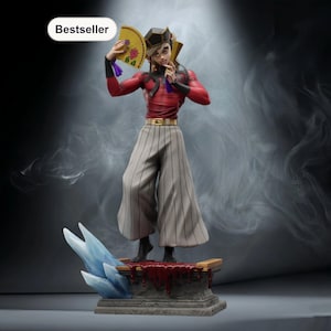 Puede incluir: Figura de un personaje con una parte superior roja y negra, pantalones a rayas grises y un sombrero negro, sosteniendo un abanico. La figura se encuentra sobre una plataforma con una sustancia similar a la sangre. Una etiqueta "Bestseller" está en la esquina superior izquierda.