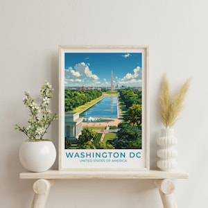 May include: A framed print depicting Washington DC, with the Washington Monument and reflecting pool. The image is set against a blue sky and green trees. The text "WASHINGTON DC UNITED STATES OF AMERICA" is visible. The print is displayed on a white shelf.