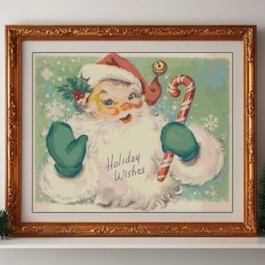 May include: A framed vintage Christmas print featuring Santa Claus with a red hat, green mittens, and a candy cane. The image has the text "Holiday Wishes" and is set against a light green background with snowflakes. The frame is gold.