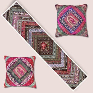 Può includere: Immagine di un runner da tavolo decorativo e due cuscini quadrati. Il runner e i cuscini presentano intricati e colorati motivi geometrici nelle tonalità del rosso, rosa, verde e blu. I disegni includono motivi floreali e paisley.