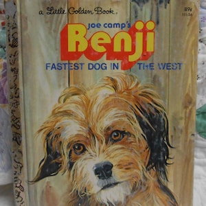 May include: A vintage Little Golden Book titled "Benji, Fastest Dog in the West." The cover features a detailed illustration of a brown and tan dog with expressive eyes. The title is in large red and yellow letters against a wooden background.
