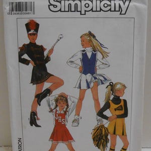 May include: Simplicity pattern for children's costumes. The image shows illustrations of four different outfits: a marching band uniform, a cheerleader uniform, and two other cheerleading outfits. The pattern size is 9/10.