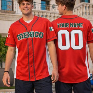 Könnte beinhalten: Rotes Baseball-Trikot mit "MEXICO" in grünen Buchstaben auf der Vorderseite. Das Trikot hat weiße Seitenteile und grüne Paspeln. Auf der Rückseite des Trikots stehen "YOUR NAME" und die Nummer "00" in Weiß. Ein mexikanischer Flaggenaufnäher befindet sich auf dem Ärmel.