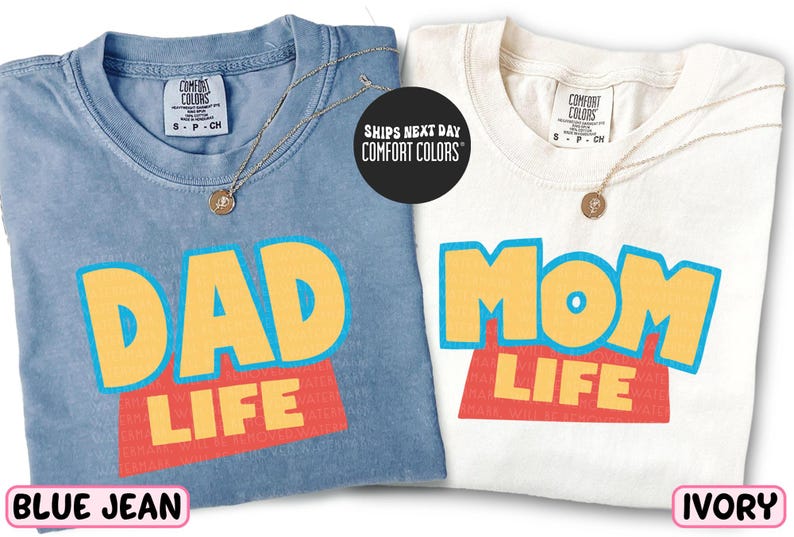 two t-shirts with the text "DAD LIFE" printed on them, one in blue and one in white.