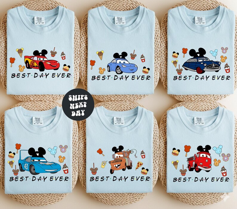 six identical light blue t-shirts with the phrase "BEST DAY EVER" printed on them, featuring various Disney characters and vehicles.