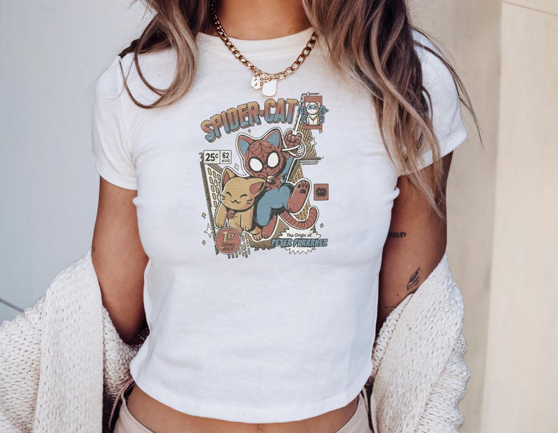 A person wearing a white t-shirt with a Spider-Cat graphic and a necklace.