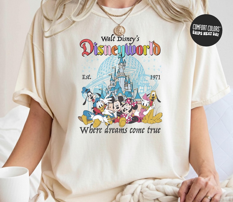A person wearing a white t-shirt with a Disney World logo and text printed on it.