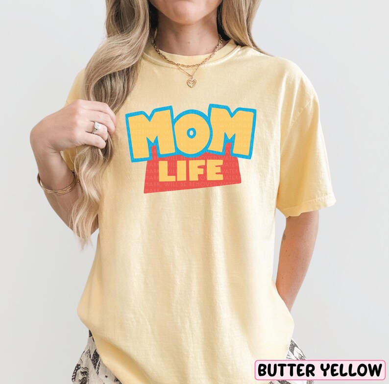 A woman wearing a yellow t-shirt with the text "MOM LIFE" printed on it.