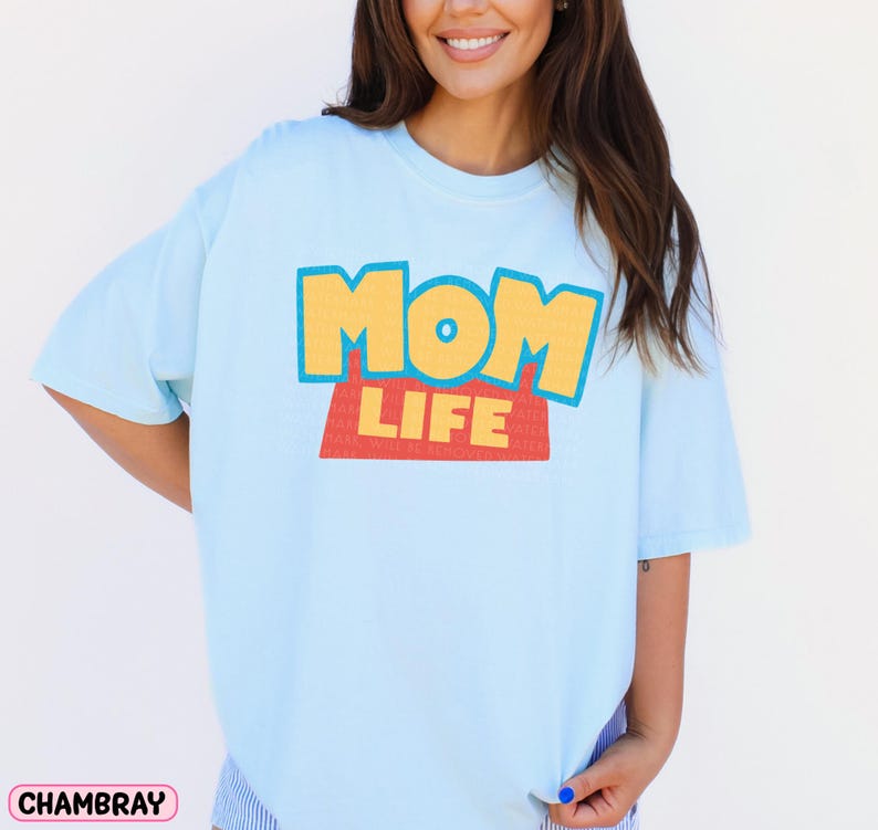 a woman wearing a blue shirt with the word mom life on it