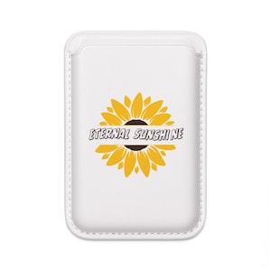 May include: White phone case featuring a yellow sunflower design with a brown center. The words "Eternal Sunshine" are printed across the sunflower. The case has a rectangular shape with rounded edges and a stitched border.