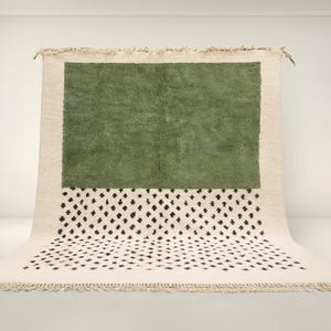 a large, square rug with a green background and a white and black patterned area on the bottom.