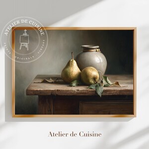 Puede incluir: Impresión enmarcada de una naturaleza muerta con dos peras, un jarrón de cerámica gris y hojas sobre una mesa de madera. Las peras son verdes y amarillas. La impresión está etiquetada como "Atelier de Cuisine".