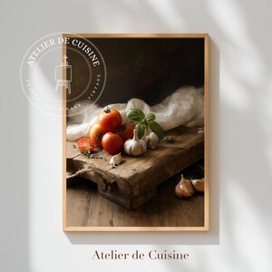 May include: A framed print featuring a still life of fresh tomatoes, garlic, and basil on a rustic wooden cutting board. The image has a vintage aesthetic, with a soft, warm color palette. The text "Atelier de Cuisine" is at the bottom.