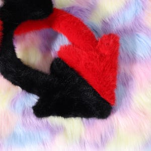 Side view of the cosplay tail attached to a belt on a mannequin waist, posed in a lifted arc behind the hip. The wire core keeps the arc without drooping, and the plush surface hides the internal structure. The belt loop sits flush with the waistband for a clean look. Shot at mid distance with neutral gray backdrop, the image highlights proportion for adults and teens and suggests a tail length around thirty inches for a dramatic silhouette while walking at a convention.