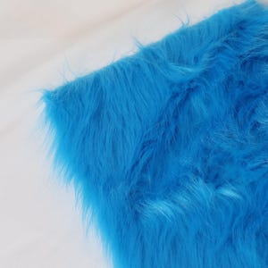 Blue faux fox fur crafted from premium synthetic fibers with a thick 5 cm pile. Ideal for animal costumes, furry cosplay, and plush detailing. Use for creating tails, ears, gloves, or wigs. The long pile mimics realistic movement, while its vibrant tone adds bold flair to your creative sewing or crafting projects. A must-have for furry creators and costume makers.
