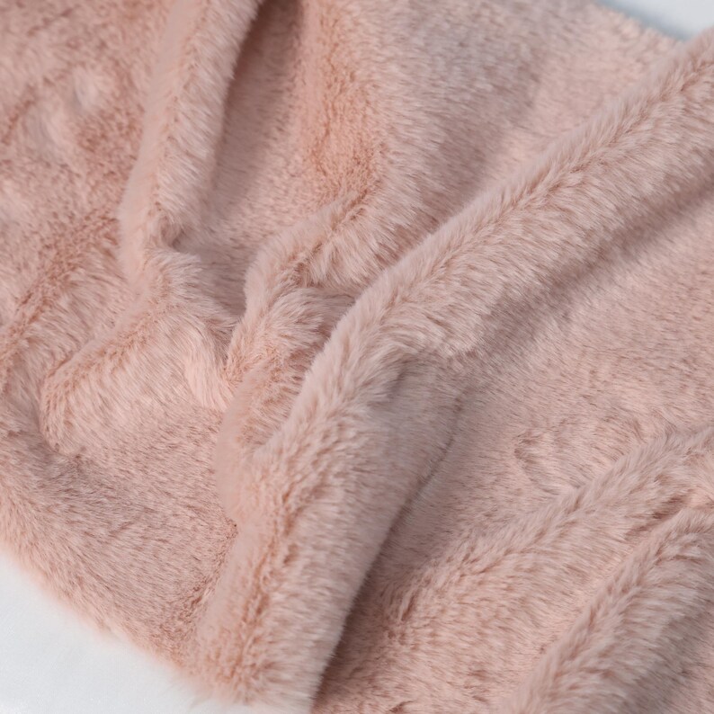 Pink faux rex rabbit fur fabric with ultra-soft touch and realistic look. Short plush pile measures approx. 0.4–0.6 in and offers comfort and warmth. Ideal for fursuit design, plush toys, DIY crafts, and cosplay accessories. Lightweight and skin-friendly for sensitive use.