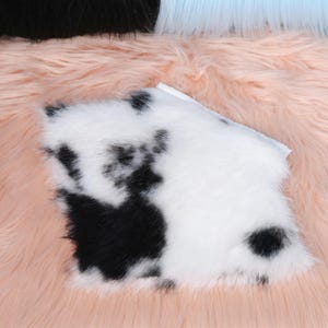 Cow pattern faux fur neck piece featuring black and white spotted design inspired by dairy cow patterns. This fursuit accessory provides soft comfort and realistic texture, ideal for cosplay events or furry costumes. Fully lined with smooth inner fabric to prevent irritation and maintain warmth during long convention days or performances. Handmade for durability and authenticity.