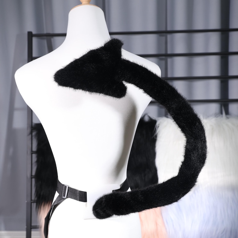 Studio photo of multiple color swatches placed beside the tail base to suggest customization options like black, deep red, or midnight blue. The selected tail remains monochrome for versatility. The belt loop fabric matches the tail shell for a cohesive look. The image emphasizes neat construction, no loose threads, and a clean seam junction. It helps buyers visualize pairing the tail with horns, gloves, capes, or thigh high boots for a complete gothic or fantasy themed costume.