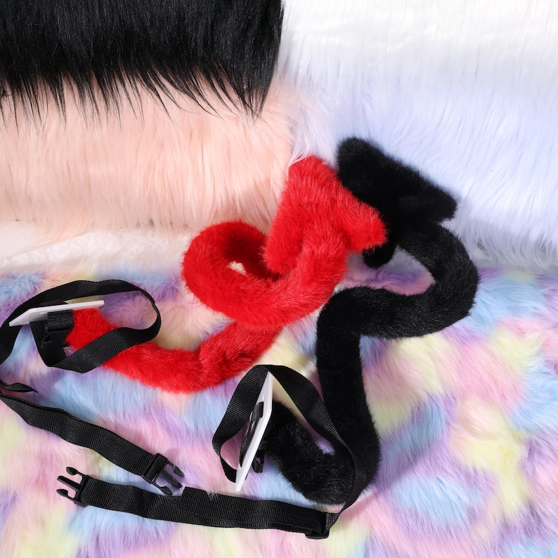 Detail of the belt loop and stitching where the tail meets the loop, showing reinforced box stitches and hidden knots for durability. A ruler is not pictured, but the loop is sized for common belts about one inch wide. The plush fabric nap runs smoothly toward the tip to mimic natural fur direction. The color appears deep charcoal or black, suitable for gothic styles, vampires, demons, or succubus looks, and the finish avoids glare under bright stage lights or camera flash.