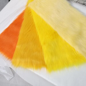 Faux fur fabric with vibrant yellow tones and a 2 inch pile, perfect for creating sunny animal characters, fantasy wigs, or furry plush toys. The synthetic material is soft and plush, yet durable enough for repeated use. Use for fursuit features or costume props where bold color and fluffy texture are needed.
