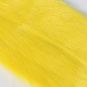 Yellow faux fox fur fabric with a long pile and realistic fox-like texture. Made from synthetic fibers for animal-friendly use. This 20 × 50 cm cut is great for adding color to fursuit accessories, plush toys, or cosplay accents. The fur is dense yet soft, easy to shape and perfect for fun, colorful characters.