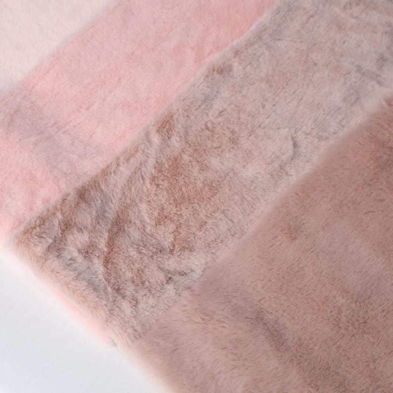 Short pile faux rabbit fur in pink hues, made of synthetic plush fiber with a soft and dense texture. The 25 × 50 cm fabric cut is ideal for fursuit trim, small accessories, costume details, and plush creations. Its gentle texture mimics real rex rabbit fur, offering warmth and comfort for wearable crafts.