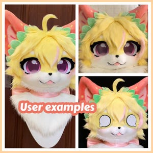 May include: A plush animal head mask featuring bright yellow fur, large purple eyes with black lashes, and pink inner ears. The design includes green leaf-like accents around the head, a white muzzle, and a small pink tongue visible at the mouth.