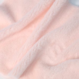 Faux fur fabric in soft pink color, made with plush synthetic fiber to mimic rex rabbit texture. The short pile is ideal for fursuit cheek pads, plush toy paws, or costume embellishments. Sized at 25 × 50 cm, it’s easy to manage for beginner-friendly sewing and cozy crafts.