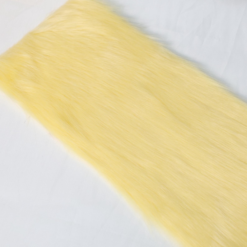 Golden yellow faux fox fur with a 5 cm pile for fursuit detail work and costume crafting. Use it for making ears, tails, paws, or trim. The soft texture and lightweight build make it easy to sew and style. Ideal for small-scale DIY projects, fantasy cosplay, or plush animal designs that need warmth and brightness.