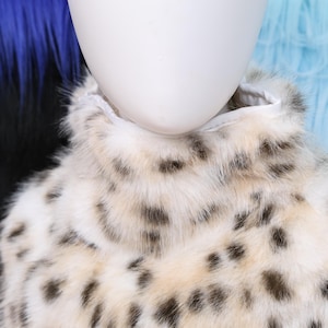 Leopard print faux fur neck fluff designed for fursuit builders and animal-themed costume lovers. The pattern features warm brown tones with black and gold spots, creating a realistic appearance. Its smooth inner lining prevents irritation, allowing for all-day comfort during cosplay events, parades, or photo shoots.