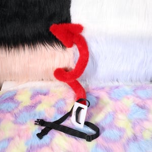 Three quarter angle photo of the demon tail posed in a sharp coil, demonstrating maximum bend. The coil shows consistent thickness from base to midsection, then a smooth taper to the tip. No internal wire shows through the seams. The photo suggests light weight suitable for long wear, and the balanced stiffness keeps the shape during motion. Shot on a tabletop with soft shadows that define contours, it helps viewers imagine dynamic shapes for selfies or cosplay skits at events.