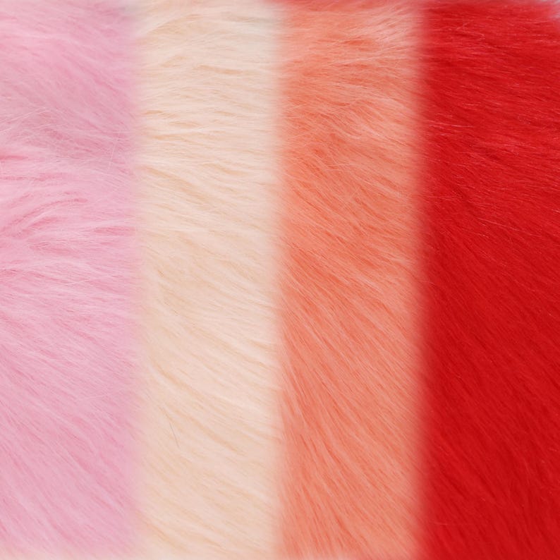 May include: Close-up of a colorful faux fur fabric with vertical stripes. The colors include light pink, cream, peach, and red. The soft, fluffy texture is visible in the image.