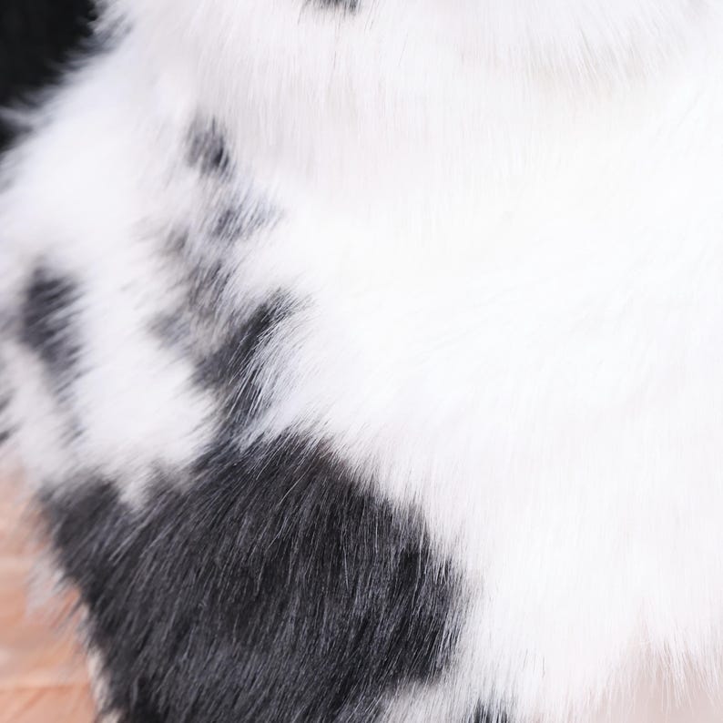 Cow-inspired neck fluff accessory designed with soft faux fur in traditional black and white pattern. Ideal for cosplay, Halloween, and furry events, this piece adds texture and charm to any character outfit. Smooth inner lining enhances comfort, while high-density faux fur fibers mimic natural hair sheen and movement.