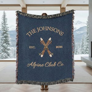 Personalized alpine blanket displayed as woven cotton throw in a ski chalet style mountain cabin living room navy