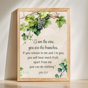 May include: A framed print featuring a watercolor illustration of grape vines and a cluster of grapes. The text reads "I am the vine, you are the branches." The artwork is set against a cream-colored background, with the text "John 15:5" at the bottom.