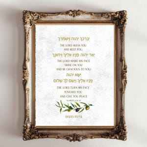 Könnte beinhalten: Gerahmter Druck mit einem goldenen, verzierten Rahmen. Der Druck zeigt Text in Hebräisch und Englisch sowie eine Olivenzweig-Illustration. Der Text enthält einen Segen aus Numeri 6:24-26.