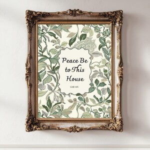 May include: A framed print with a floral design in shades of green and cream. The text "Peace Be to This House" is centered within an oval shape. The frame is ornate with a gold finish.