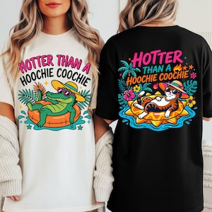 Puede incluir: Una camiseta blanca con un caimán verde en un flotador con gafas de sol y el texto "HOTTER THAN A HOOCHIE COOCHIE" y una camiseta negra con un gato en un flotador con gafas de sol y el mismo texto en gráficos coloridos.