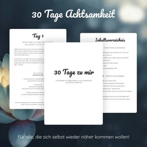 Könnte beinhalten: Drei weiße Seiten mit deutschem Text, darunter "30 Tage zu mir" und "30 Tage Achtsamkeit", vor einem dunklen, verschwommenen Hintergrund mit einer Lotusblume. Das Bild wirbt für Achtsamkeit.