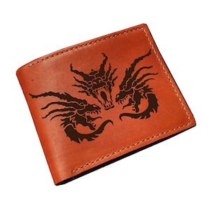 May include: A brown leather wallet featuring a black dragon design. The wallet is rectangular and has a bi-fold design. The dragon design is centered on the front of the wallet.
