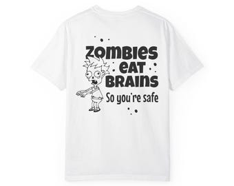 May include: White t-shirt with a black graphic of a zombie and the text "ZOMBIES EAT BRAINS So you're safe." The zombie has spiky hair and is reaching out with one arm. Black splatters are around the text and image.