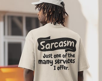 May include: A beige t-shirt with the word "Sarcasm" in a black banner, and the text "Just one of the many services I offer." The person in the image is wearing a light gray baseball cap.